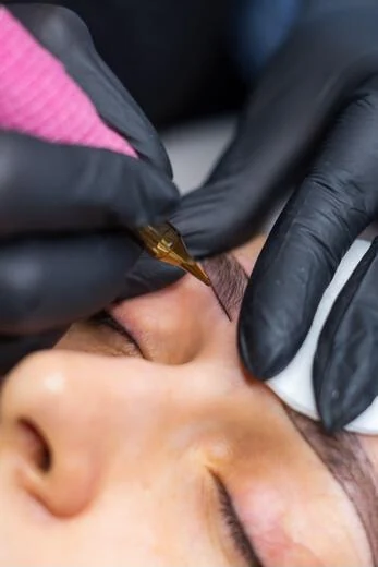 Brow embroidery procedure on a client at close range