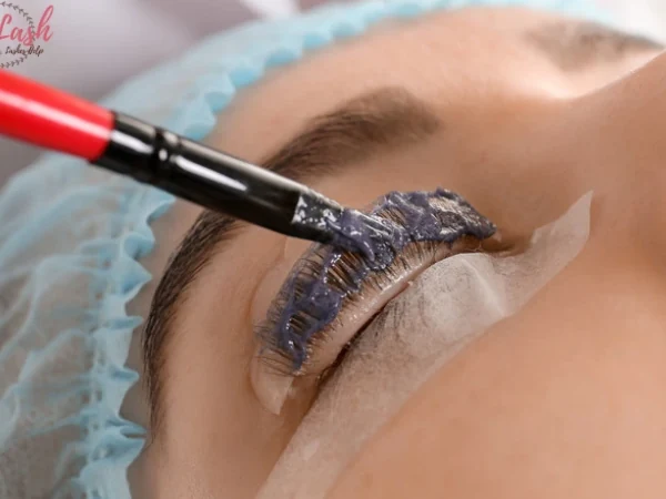 Close-up eyelash tint application with the eye area protected
