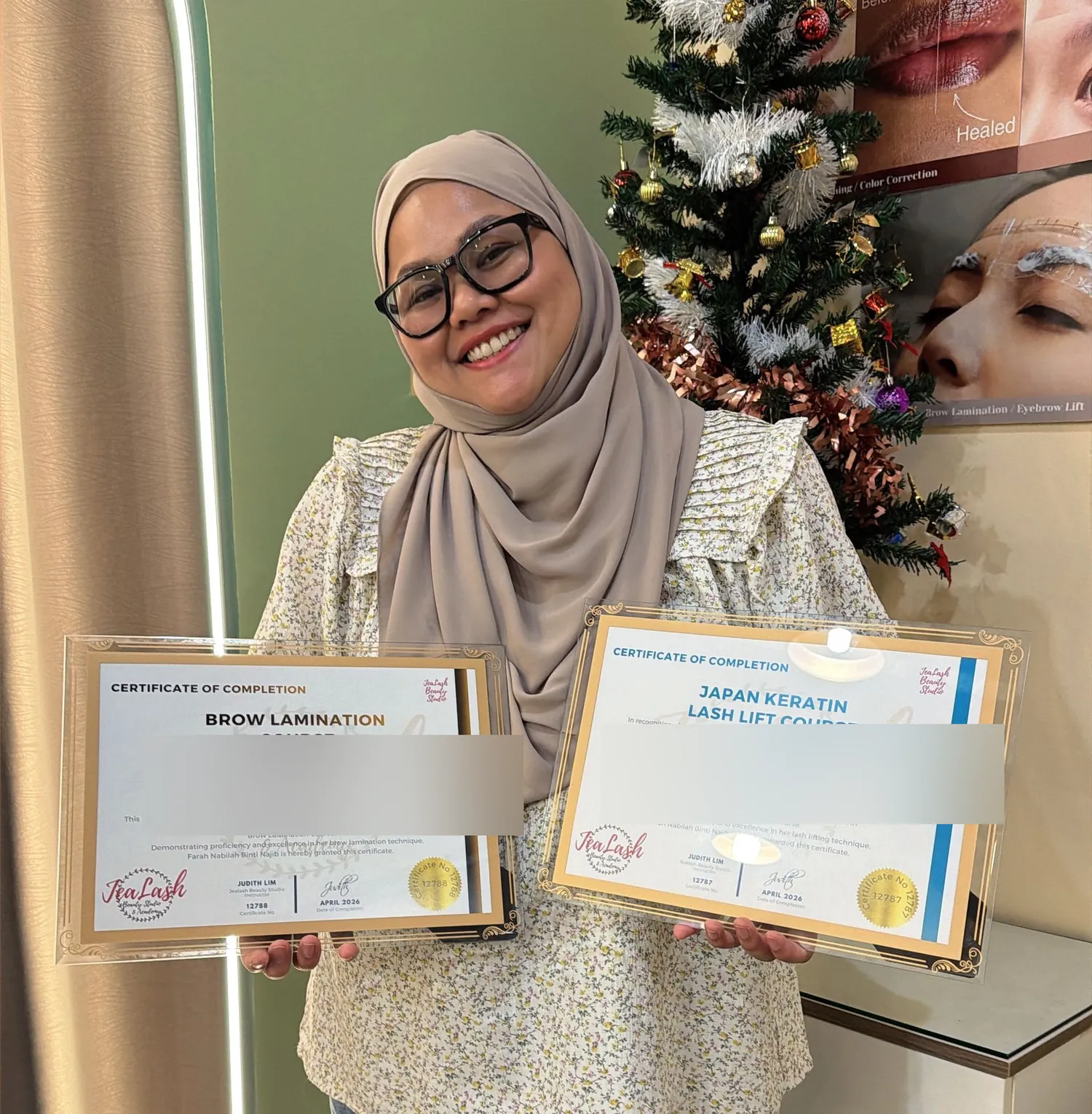 Jealash graduate holding Lash Lift and Brow Lamination certificates with student names obscured for privacy