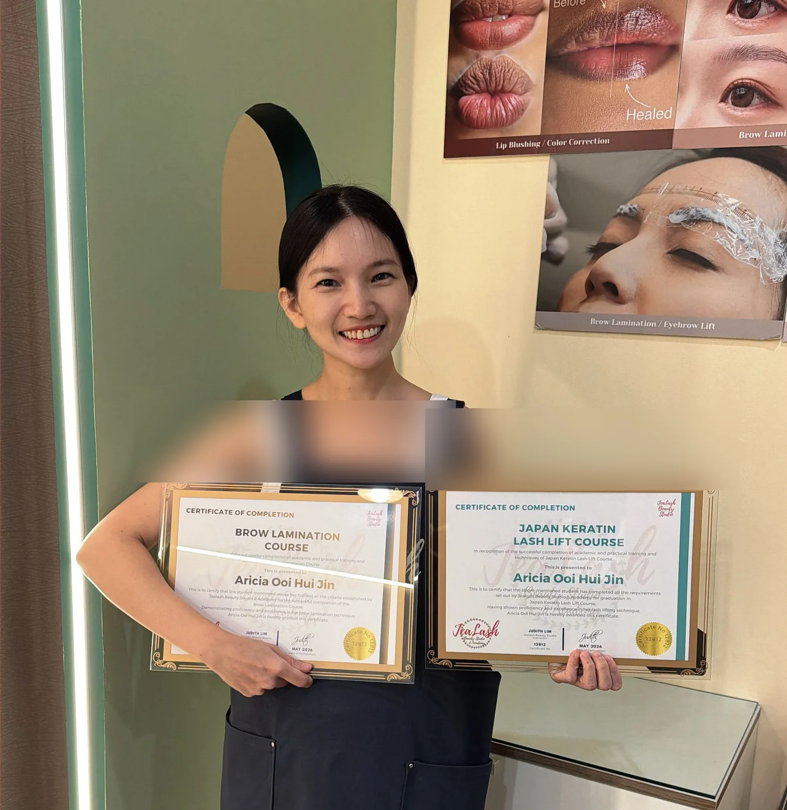 Jealash graduate holding Lash Lift and Brow Lamination certificates with student names blurred for privacy