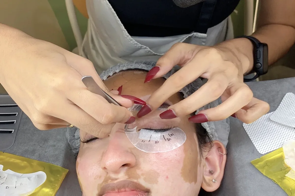 Lash artist working with a client in a professional treatment space