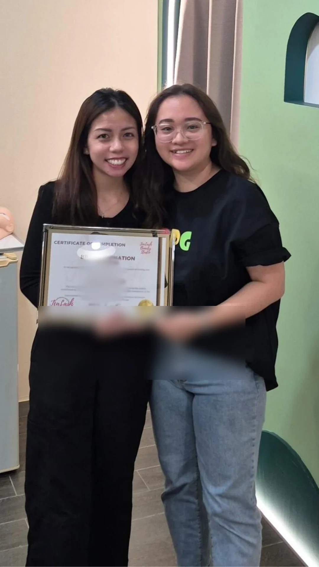 Jealash graduate holding a privacy-blurred course completion certificate