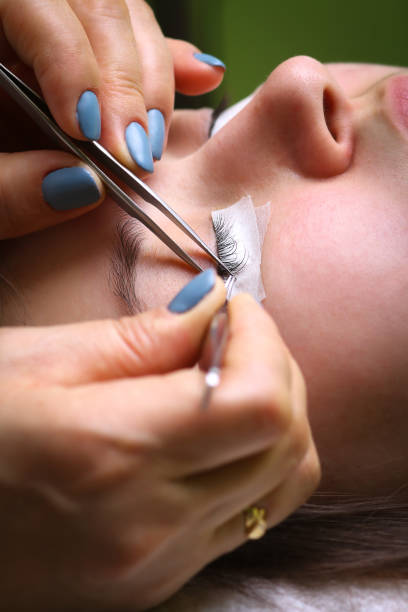Close-up lash extension placement with tweezers